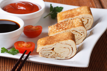 Japanese omelet tamago with two sauces closeup. Horizontal