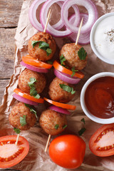 meatballs on skewers and vegetables vertical top view, rustic