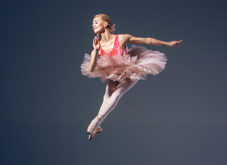 Beautiful female ballet dancer on a grey background. Ballerina