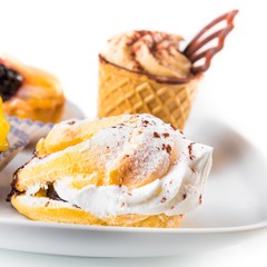 delicious little cream cake near cake with chocolate and fruit