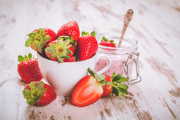 Spring fruits, strawberries with strawberry yogurt on a vintage 