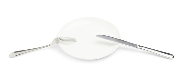 Knife and fork over the plate isolated