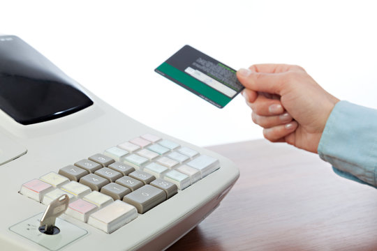 Cashier Holding Credit Card in Cash Register