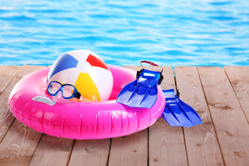 Bright beach accessories on pool background