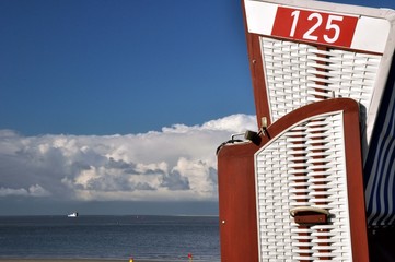 ein weißer  Strandkorb am blauen  Meer