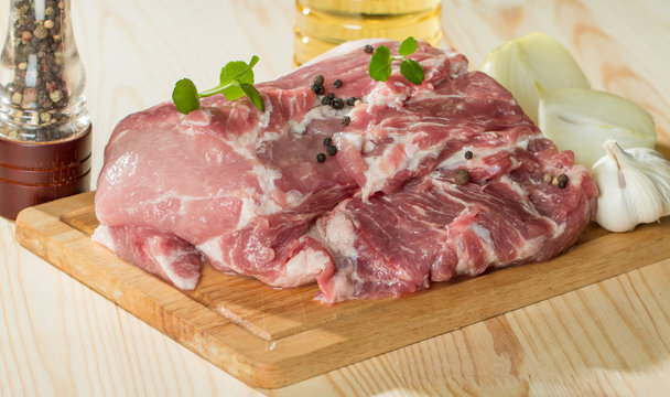 Fresh raw pork on light wooden cutting board