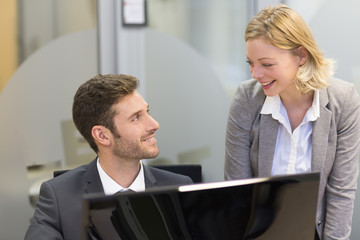 Two business people in a office, working on computer