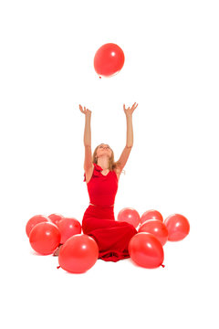 woman plays with red balloons