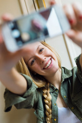 Young beautiful woman taking a selfie with smartphone in her new