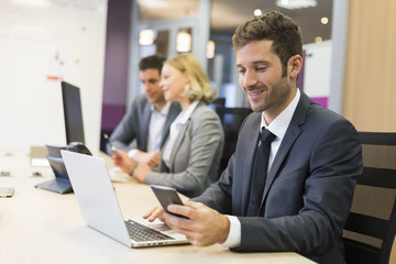 Businessman on mobile phone in office, sms, message