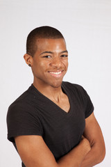 Black man in black shirt smiling at the camera