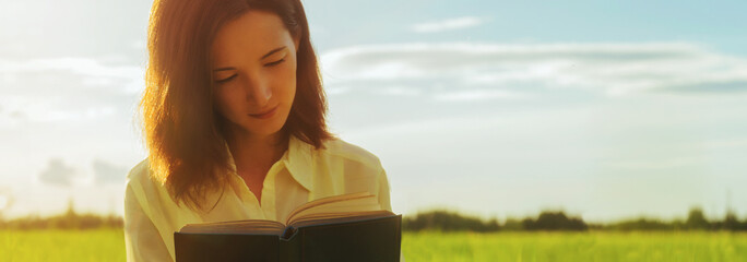 Young woman reading a book in summer