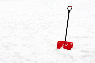 Red plastic shovel with black handle stuck in fluffy snow. - 76362586
