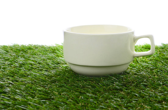 Ceramic cup on green field