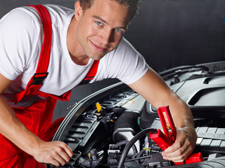 Car mechanic in a garage checks a car