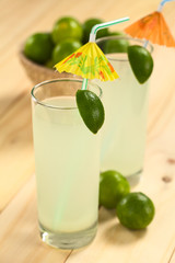 Freshly prepared refreshing lemonade out of limes in tall glass