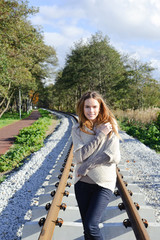 Portrait of beautiful caucasian woman walking on railways