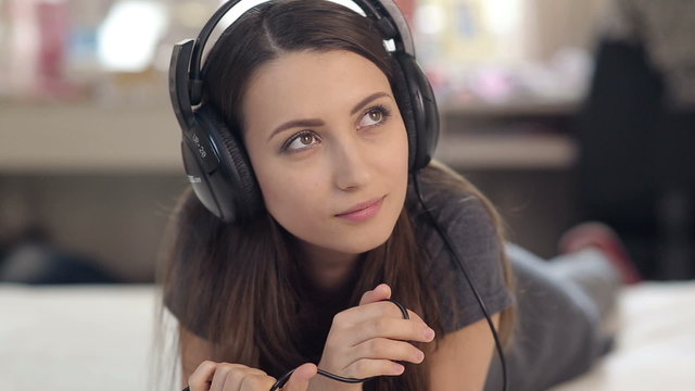 Pretty Girl in Headphones Listening Music in Bed