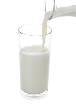 pouring milk into glass isolated on white