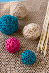 Colorful balls and wooden needles lying on beige