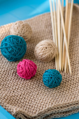 Fototapeta na wymiar Colorful balls and wooden needles lying on beige