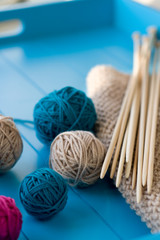 Fototapeta na wymiar Bright balls of yarn, wooden knitting needles, knitted blanket