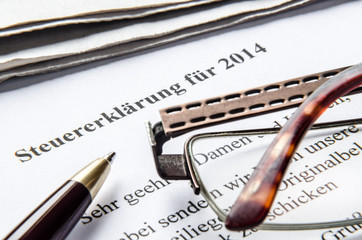 Steuererklärung 2014 mit Stift Brille und Zeitung