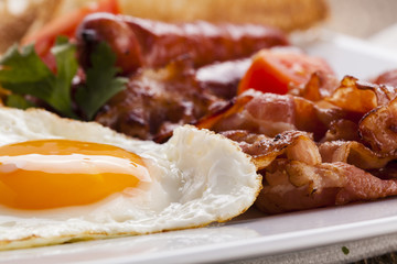 Full english breakfast with bacon, sausage, fried egg, baked bea