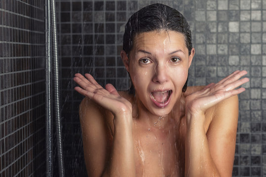 Junge Frau reagiert &uuml;berrascht auf hei&szlig;es oder kaltes Wasser
