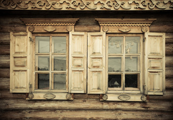 Windows with shutters, patterned on the wall of the old wooden h