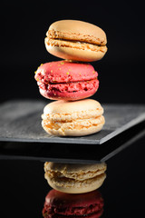 stack of colorful french macaroon on a slate black background