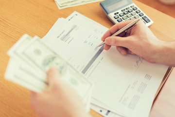 close up of man counting money and making notes