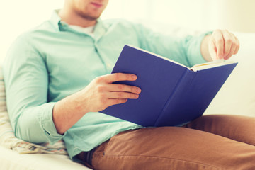 close up of man reading book at home