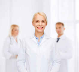Obraz premium smiling female doctor with group of medics
