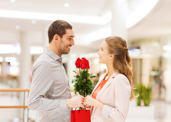 happy young couple with flowers in mall
