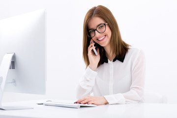 Happy businesswoman talking on the phone at office