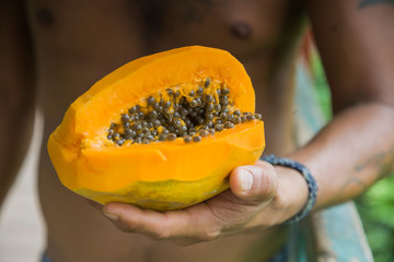 Juicy papaya in hand swarthy men