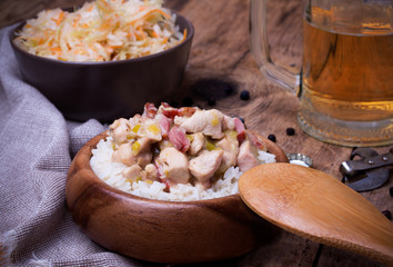 Chicken stew with rice, Sauerkraut and beer on wooden desk