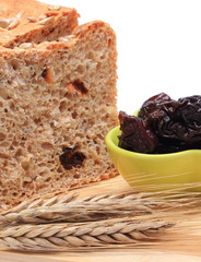 Baked wholemeal bread, dried plums and ears of wheat