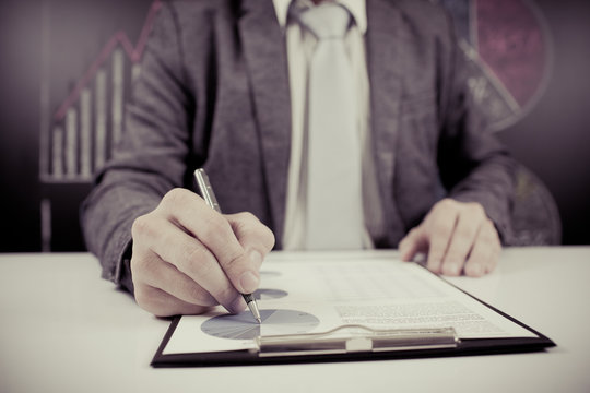 man hand with pen and business report