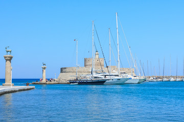 Ancient statue of a deer and a medieval lighthouse at the port o