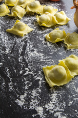 Raw ravioli on black background