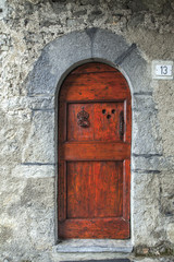 Red wooden door with large iron nails