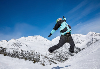 Snowboarder jumping in mountains
