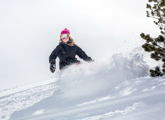 Fototapeta na wymiar Woman snowboarder in motion in mountains