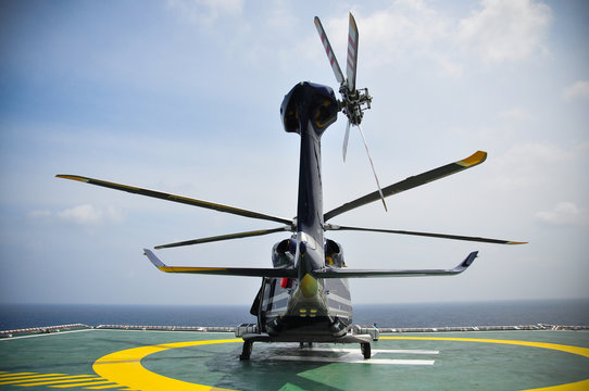 Helicopter parking on helideck and waiting passenger.