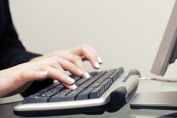 Woman typing on computer keyboard