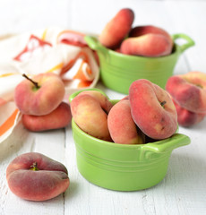 peach figs in a ceramic bowl on a white background