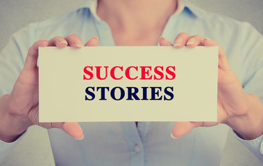 Businesswoman hands holding card sign success stories message