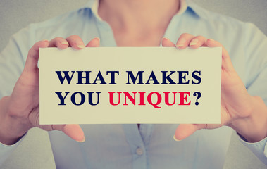 businesswoman hands holding sign message what Makes You Unique?